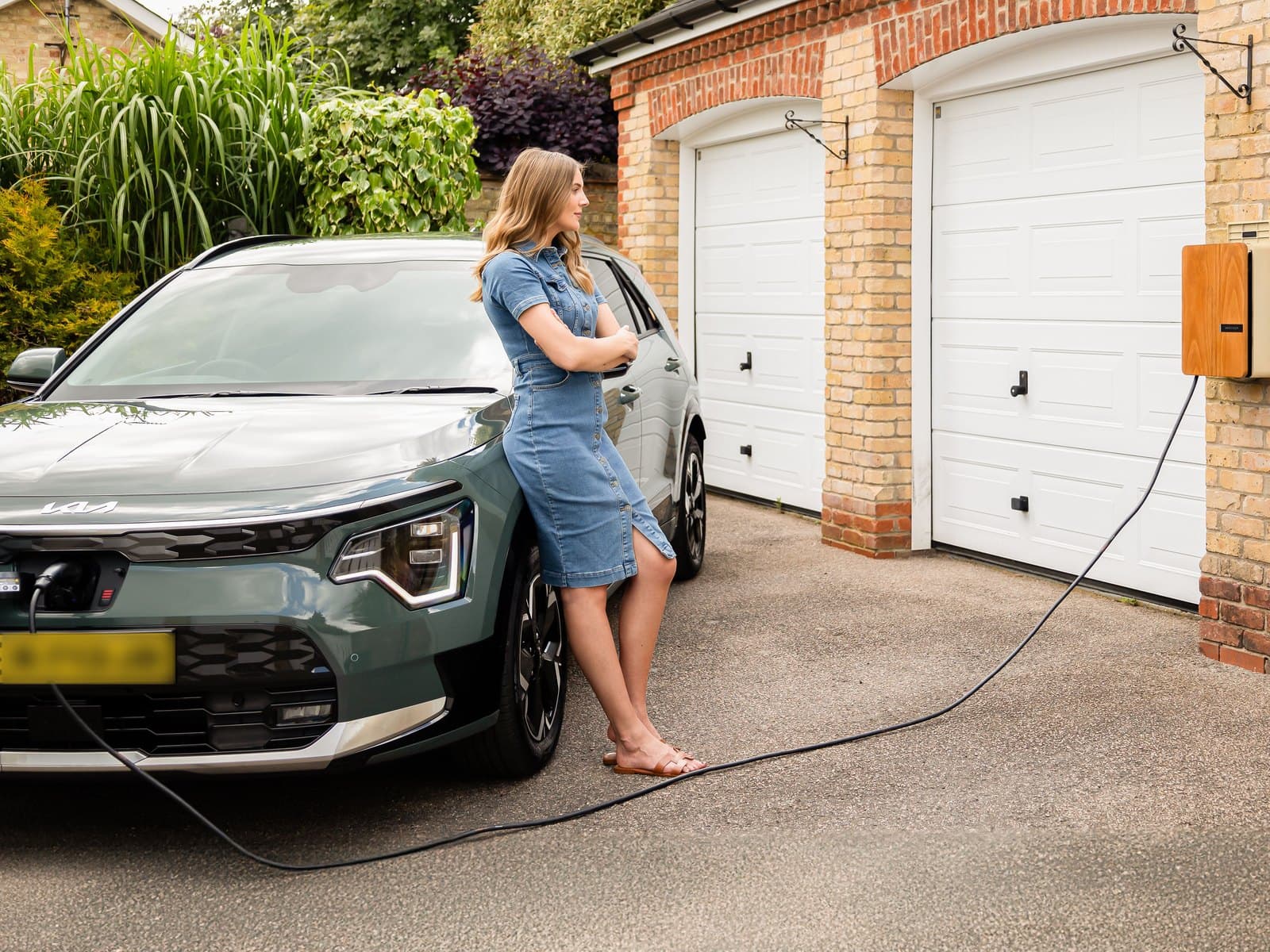 Vrouw laadt haar elektrische auto thuis op